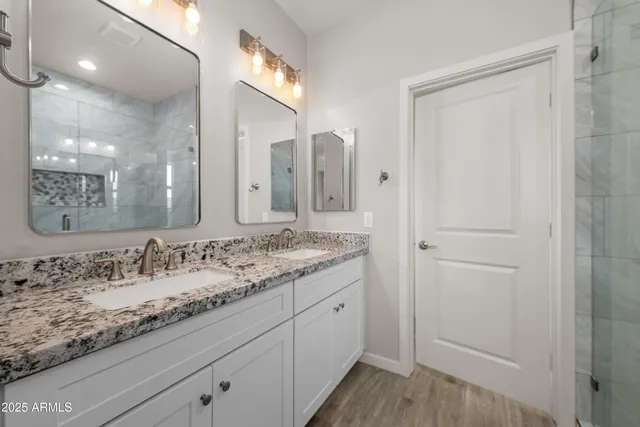 a bathroom with a granite countertop sink and a mirror