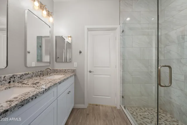 a bathroom with a granite countertop sink a shower and a mirror