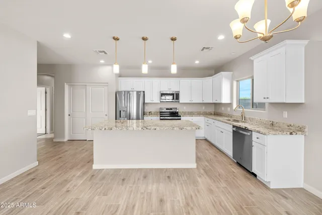 a large kitchen with cabinets wooden floor and stainless steel appliances