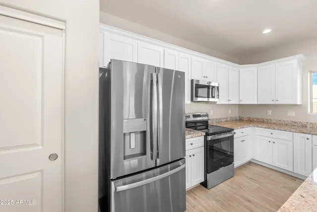 a kitchen with stainless steel appliances granite countertop a refrigerator stove and sink