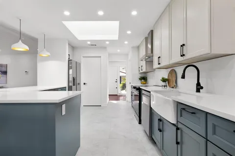 a kitchen with stainless steel appliances granite countertop a sink a stove and a refrigerator