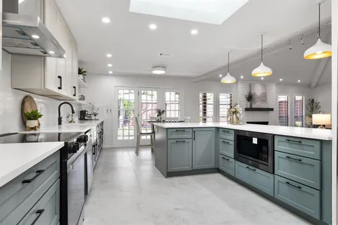 a kitchen with kitchen island a sink stainless steel appliances and cabinets