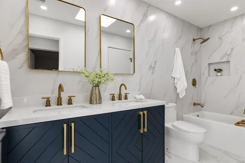 a bathroom with a sink a toilet and a large mirror