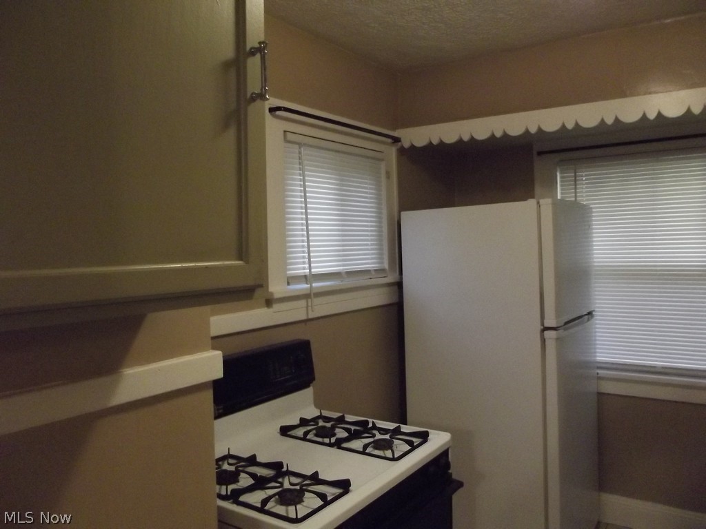 3363 Berea Road Cleveland, OH 44111 - Photo 21 of 50 Kitchen featuring white appliances and a textured ceiling