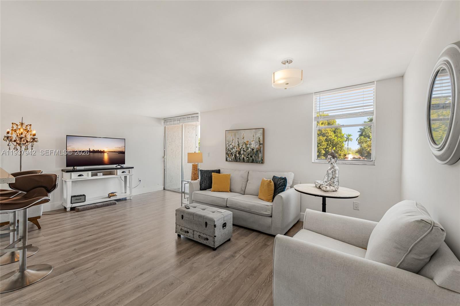 a living room with furniture a flat screen tv and a window