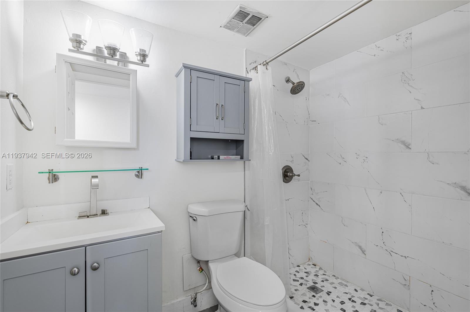 1250 Alton Road, Unit 3A Miami Beach, FL 33139 - Photo 11 of 25 a bathroom with a sink a toilet and shower