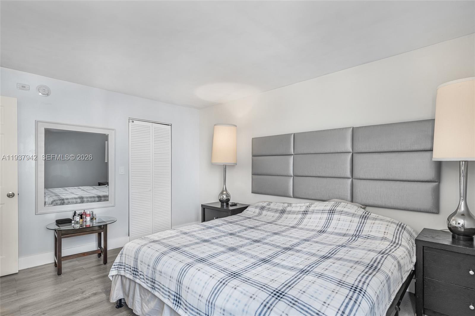 1250 Alton Road, Unit 3A Miami Beach, FL 33139 - Photo 14 of 25 a bedroom with a bed a mirror and a flat tv screen on dresser