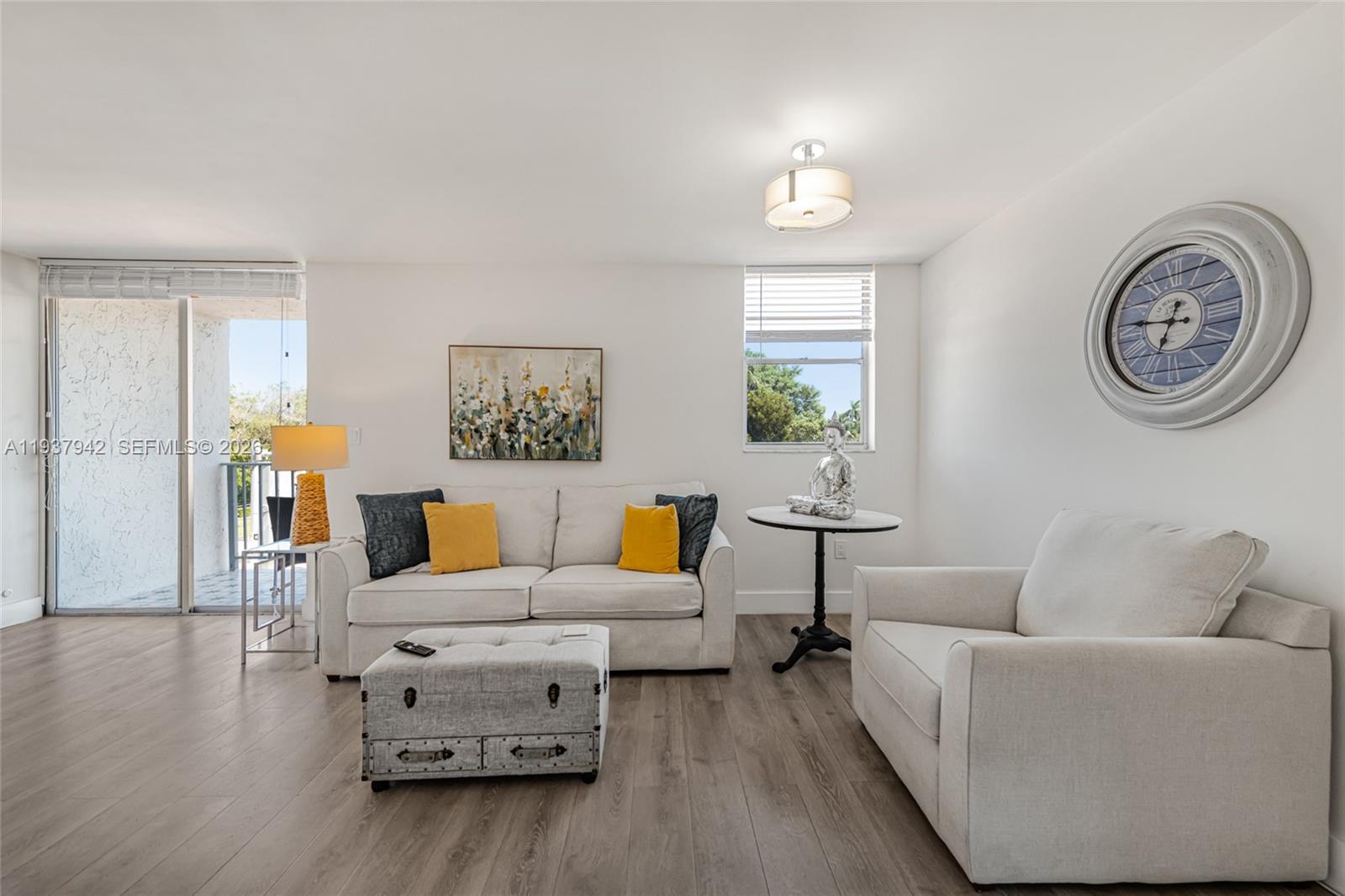 1250 Alton Road, Unit 3A Miami Beach, FL 33139 - Photo 6 of 25 a living room with furniture a clock on wall and a window
