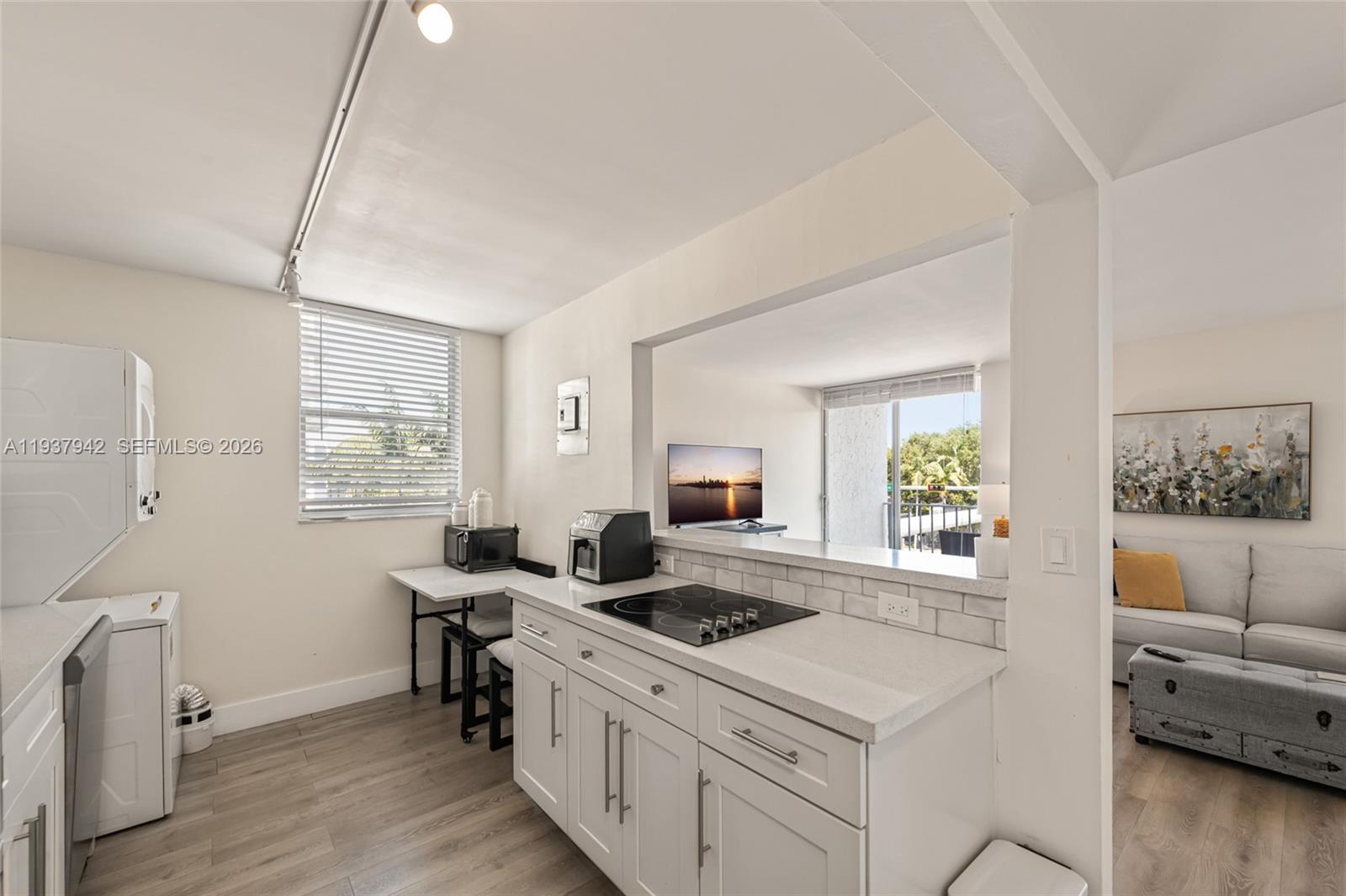 1250 Alton Road, Unit 3A Miami Beach, FL 33139 - Photo 9 of 25 a kitchen with a stove a sink and a refrigerator