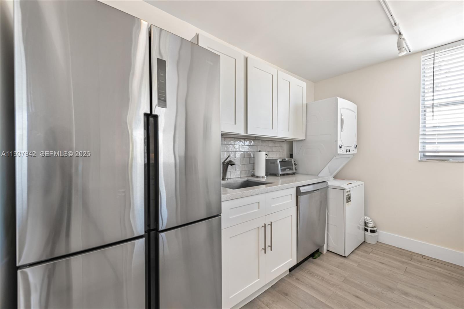 1250 Alton Road, Unit 3A Miami Beach, FL 33139 - Photo 10 of 25 a kitchen with stainless steel appliances a refrigerator sink and cabinets