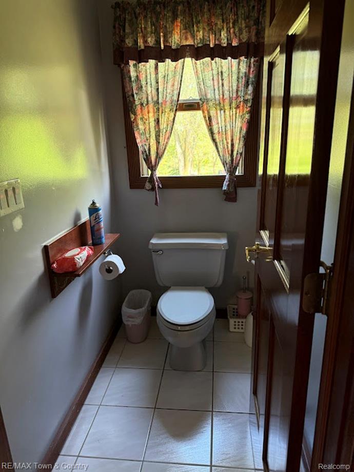 4372 North Gale Road Davison, MI 48423 - Photo 23 of 46 White ceramic tile flooring, a white toilet fixture, and a wood-framed window