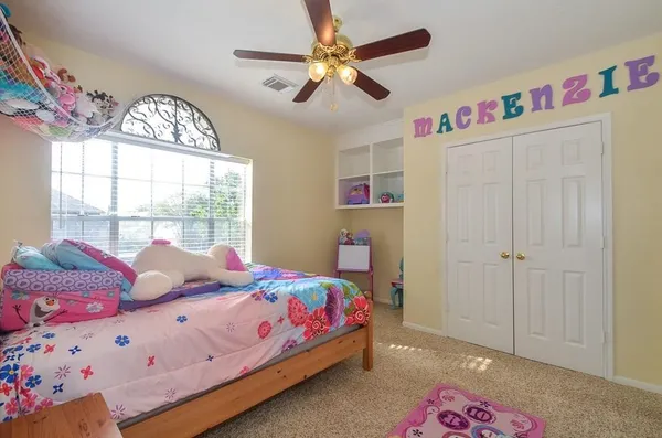 a bedroom with a bed chandelier and a window