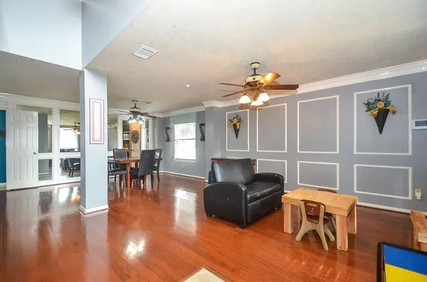 a living room with furniture two window and wooden floor