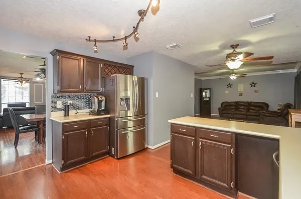 a kitchen with kitchen island sink refrigerator and cabinets