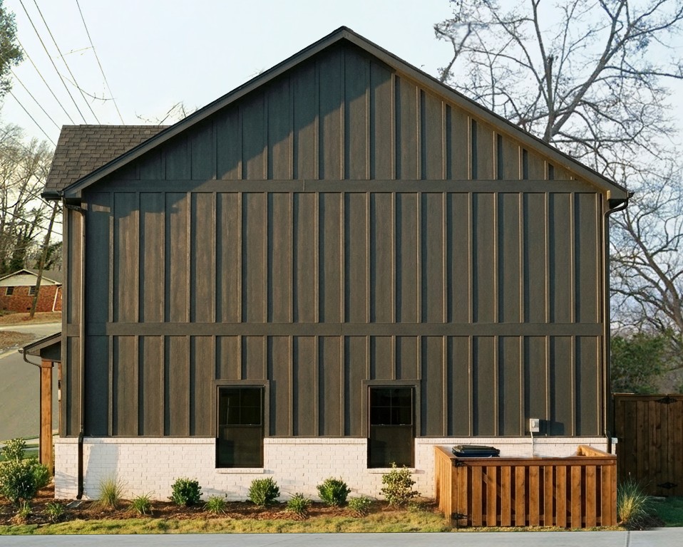 This contemporary home boasts a distinctive board and batten facade with classic brick detailing.
