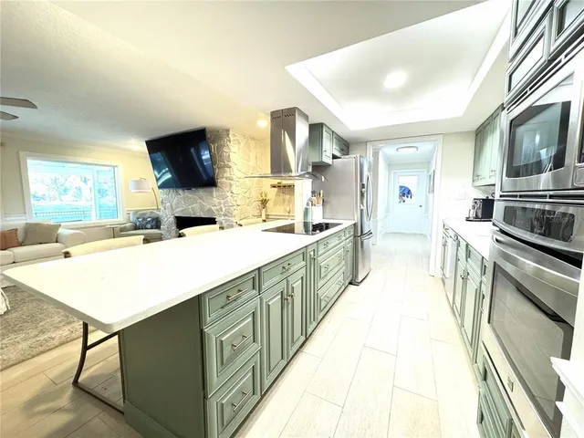 a large kitchen with kitchen island a sink appliances and a counter top space