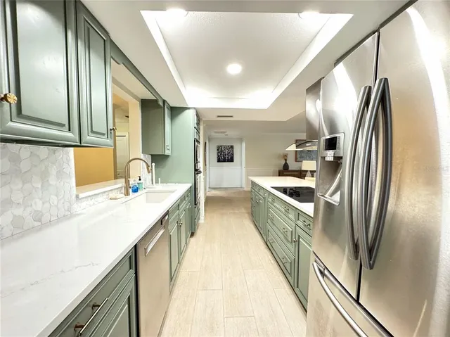 a kitchen with stainless steel appliances a sink and refrigerator