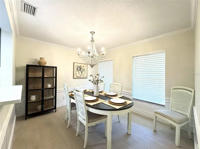 a view of a dining room with furniture and chandelier