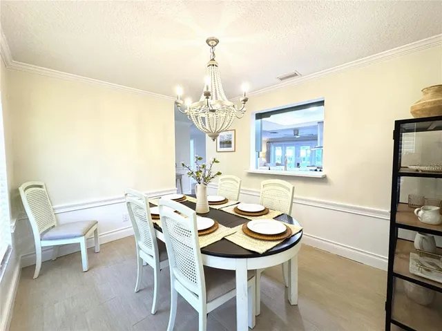 a view of a dining room with furniture and chandelier