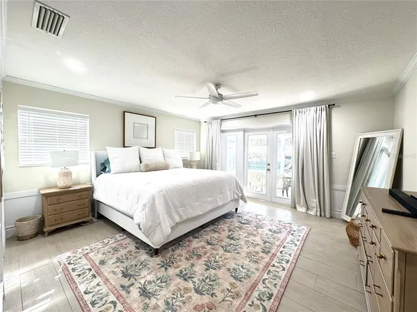 a bedroom with a bed flat screen tv and a large window