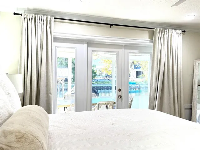 a bedroom with a bed and a large window