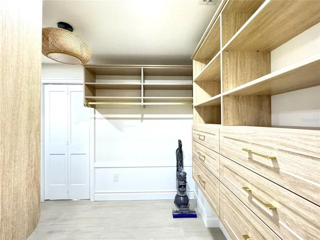 a view of walk in closet with empty racks