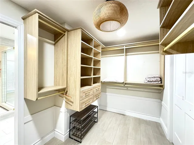 a view of a walk in closet and wooden floor