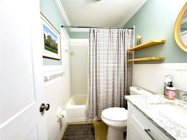 a bathroom with a granite countertop toilet a sink and a mirror