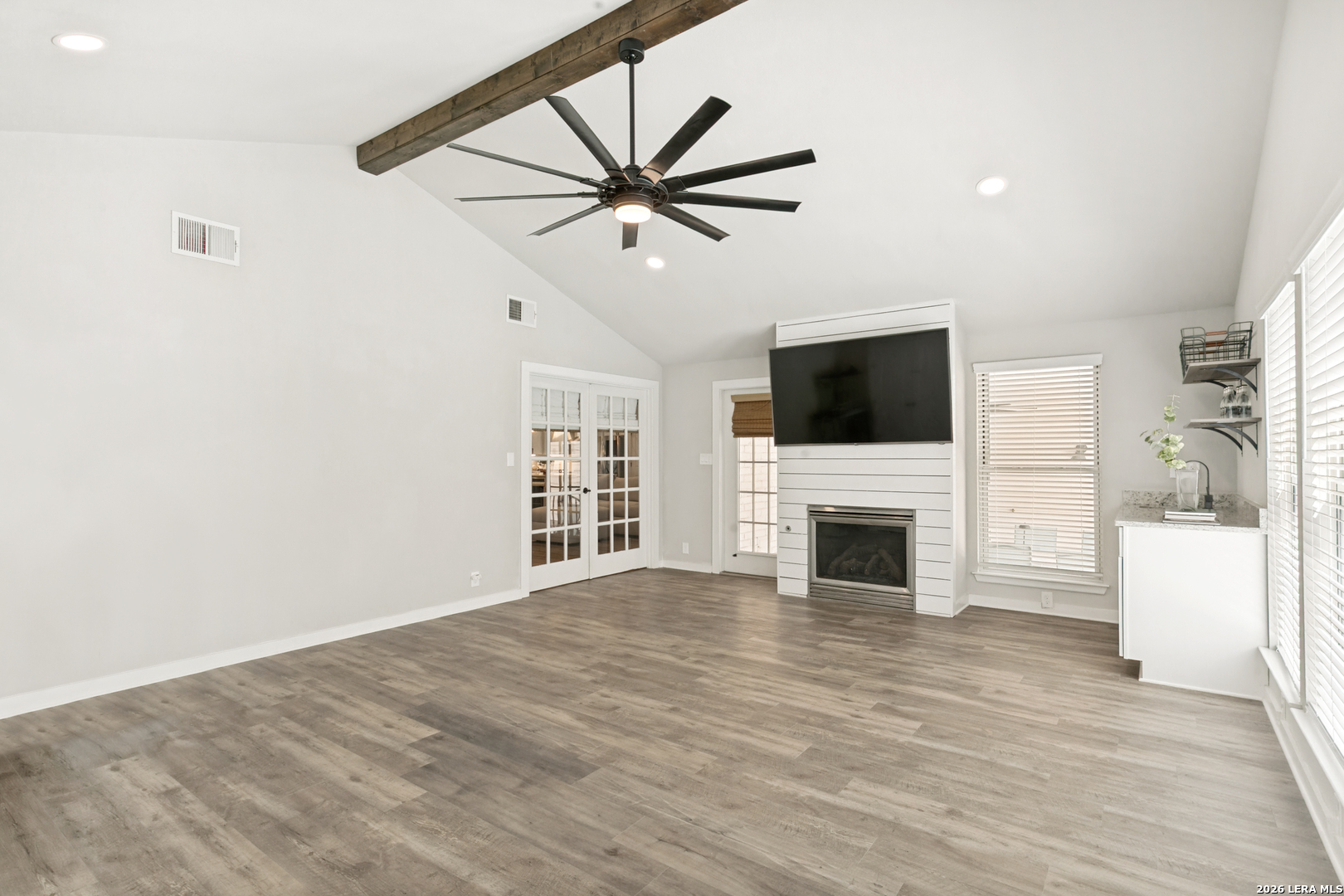 102 Silver Spring Universal City, TX 78148 - Photo 19 of 36 a view of a livingroom with a fireplace a ceiling fan and wooden floor