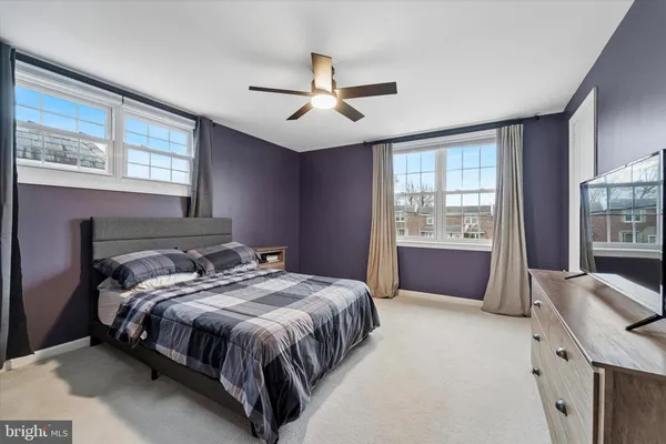 a bed sitting in a spacious bedroom next to a window