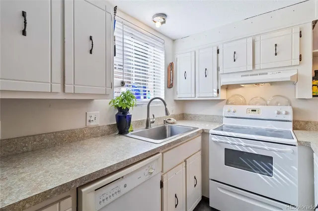 a kitchen with white cabinets and white appliances