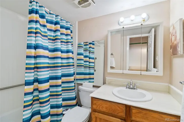 a bathroom with a sink a toilet and shower curtain