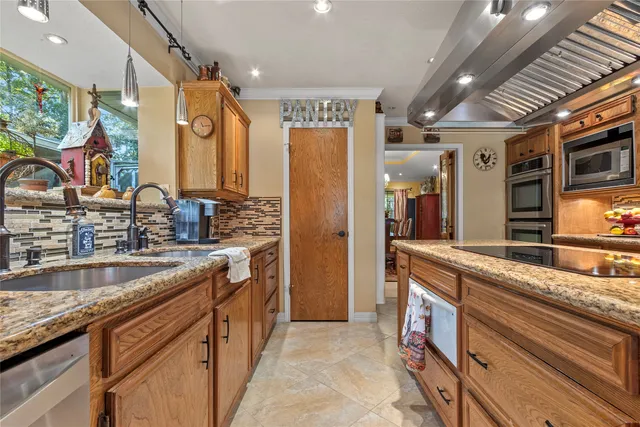 a kitchen with stainless steel appliances granite countertop a sink and a refrigerator