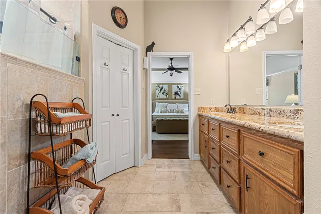 a spacious bathroom with a granite countertop sink and a mirror