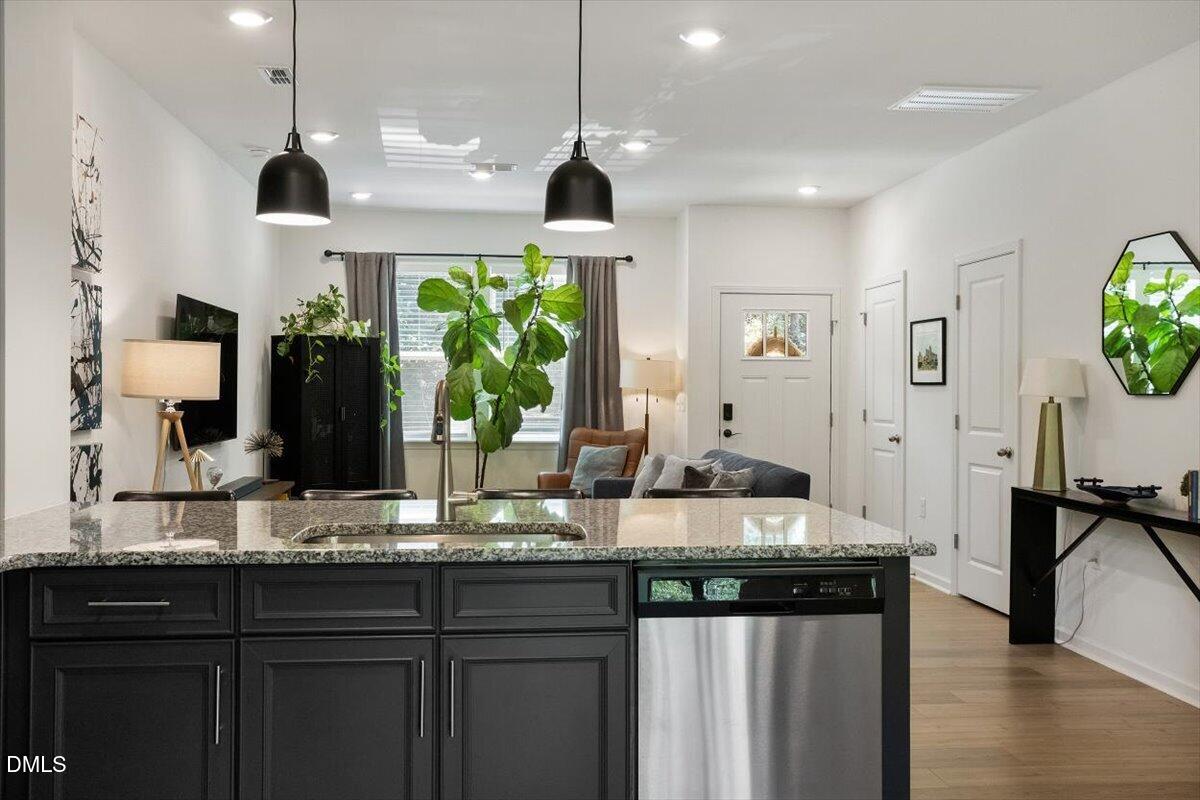 517 Hacksaw Trail Raleigh, NC 27610 - Photo 9 of 20 a kitchen with granite countertop a stove a sink and a wooden floors