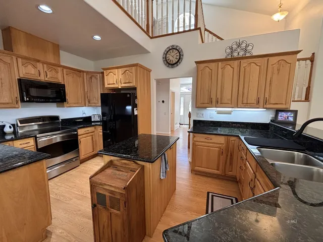 a kitchen with stainless steel appliances granite countertop a stove a sink and a microwave