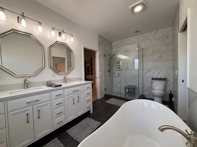 a spacious bathroom with a double vanity sink double mirror and a shower