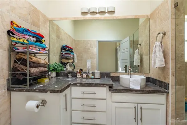 a bathroom with a granite countertop sink a toilet and shower