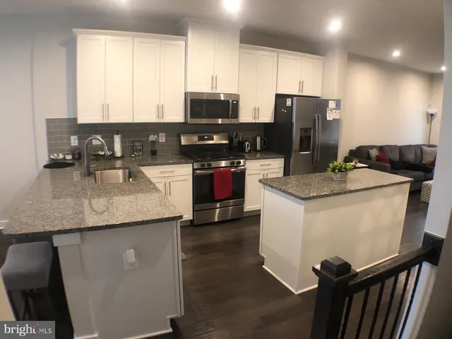 a kitchen with stainless steel appliances granite countertop a sink a stove and a refrigerator