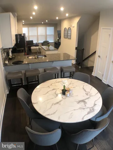 a view of a kitchen with kitchen island a dining table and chairs
