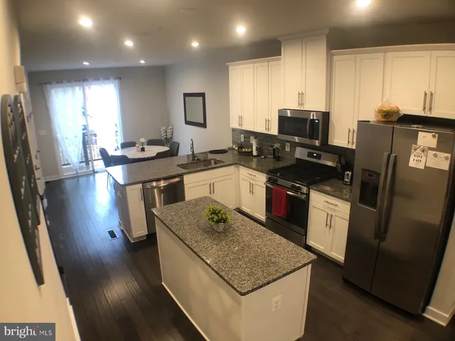 a kitchen with stainless steel appliances granite countertop a stove top oven a sink dishwasher a refrigerator and a stove