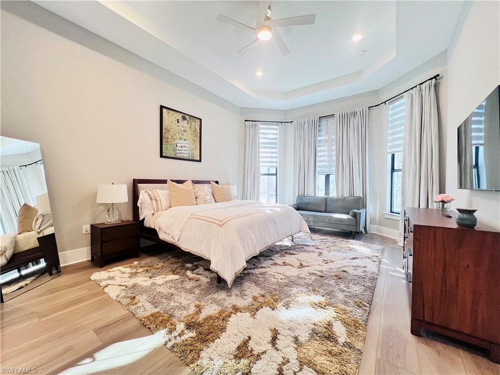 9124 Raintree Street Naples, FL 34114 - Photo 15 of 42 a spacious bedroom with a bed a couch and a dresser