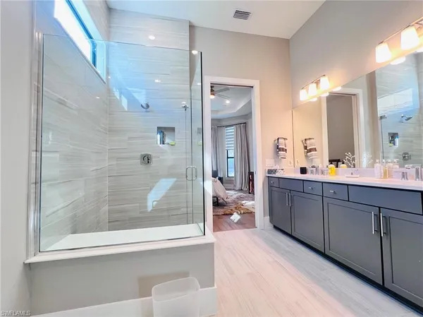 a bathroom with a double vanity sink mirror and shower