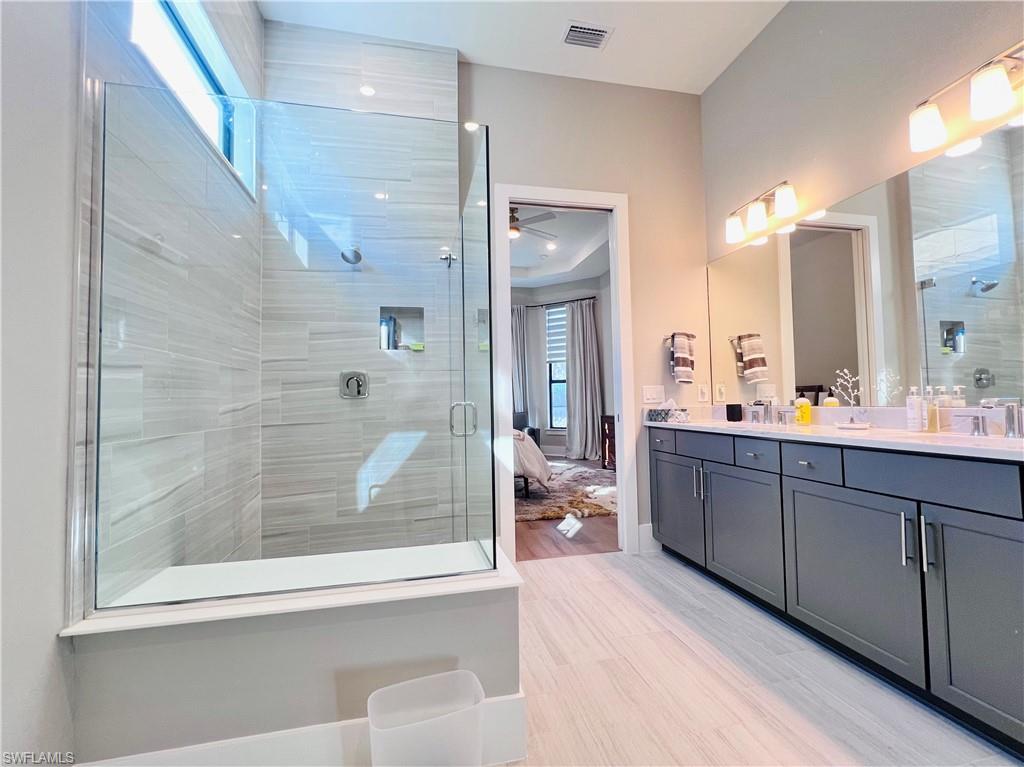 9124 Raintree Street Naples, FL 34114 - Photo 17 of 42 a bathroom with a double vanity sink mirror and shower
