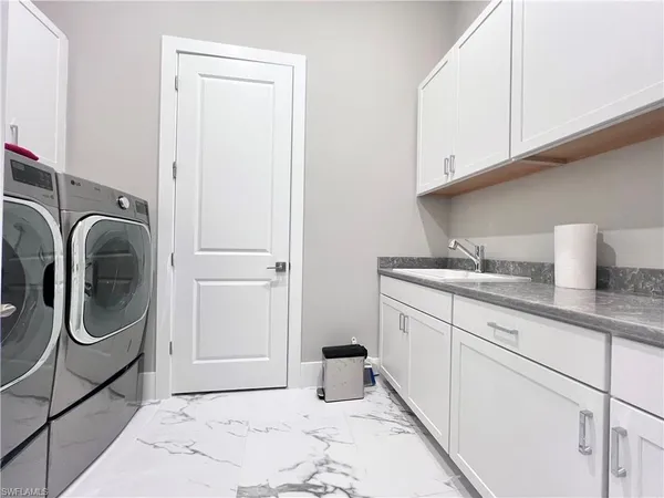 a utility room with sink dryer and washer