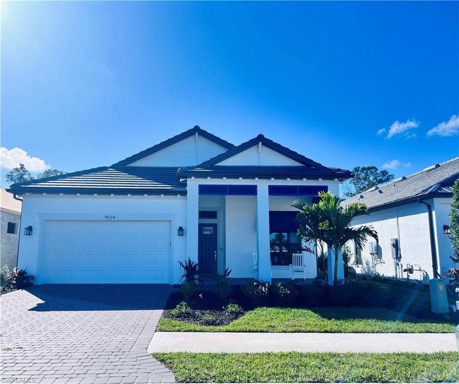 9124 Raintree Street Naples, FL 34114 - Photo 2 of 42 a front view of a house with garden