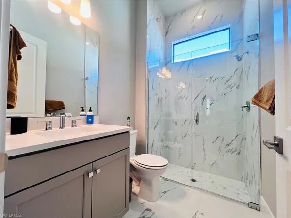 a bathroom with a sink a toilet and shower