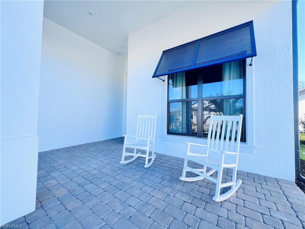 9124 Raintree Street Naples, FL 34114 - Photo 3 of 42 an empty room with wooden floor and windows