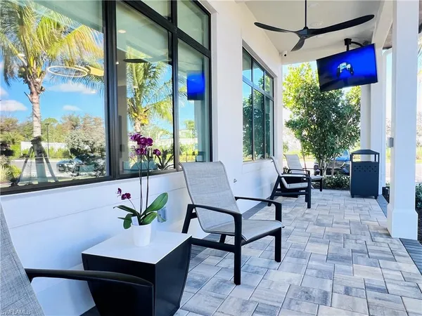 a living room with patio furniture and a potted plant