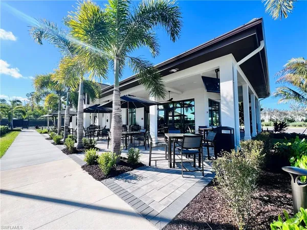 a view of the patio with table and chairs potted plants and palm tree